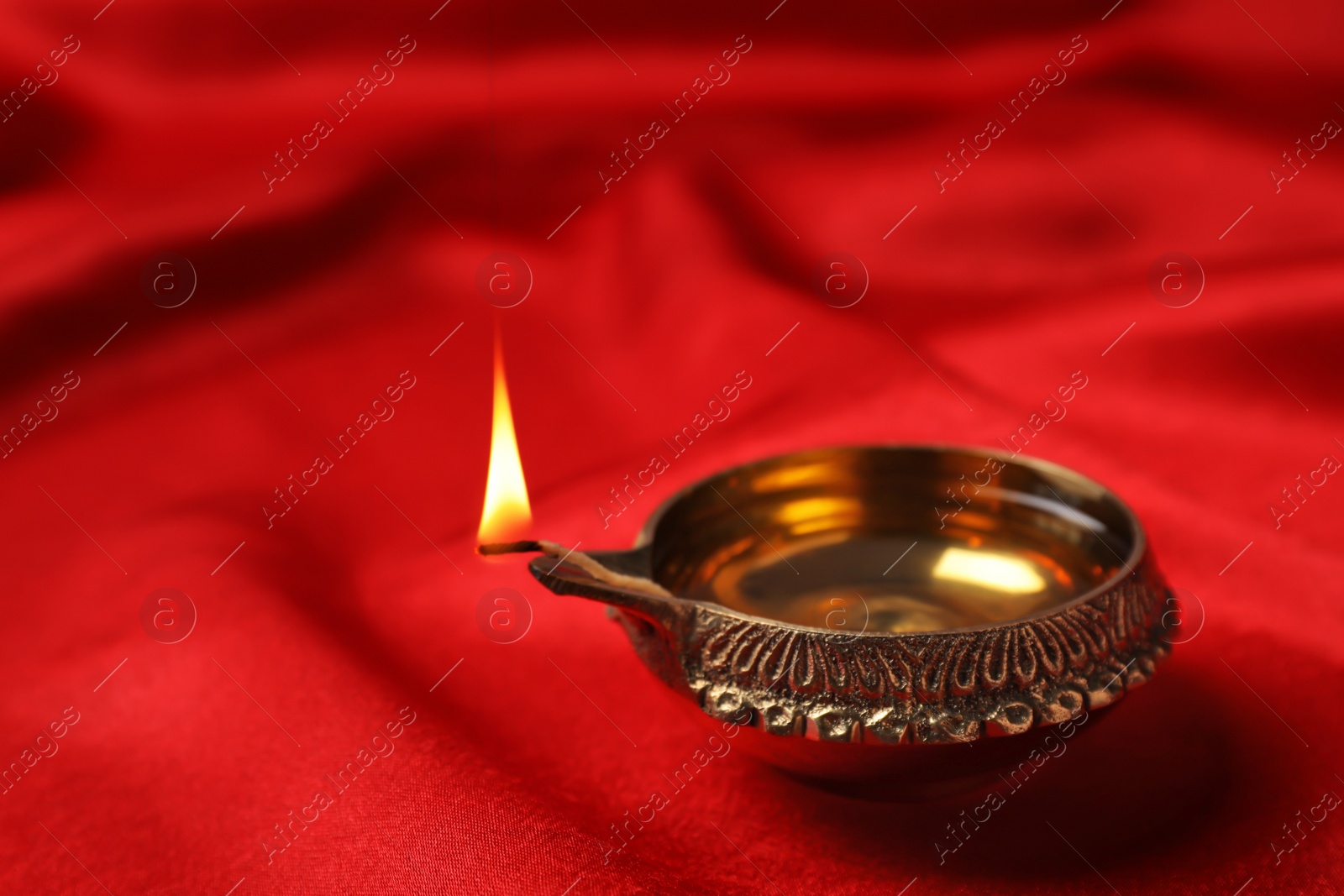 Photo of Diwali diya or clay lamp on color fabric
