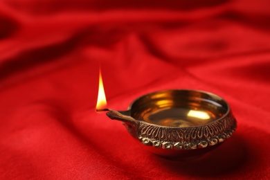 Photo of Diwali diya or clay lamp on color fabric