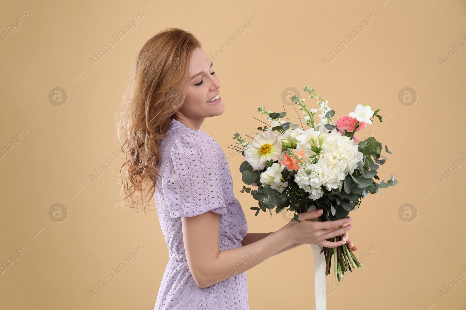 Photo of Beautiful woman with bouquet of flowers on beige background