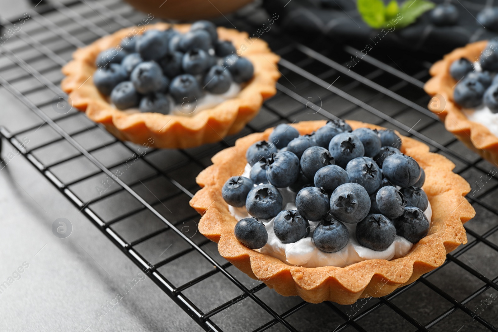 Photo of Delicious sweet pastry with berries on grey table