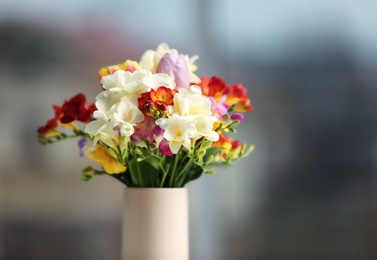 Photo of Beautiful bouquet of freesia flowers on blurred background