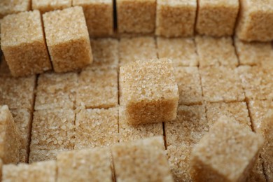 Photo of Brown sugar cubes as background, closeup view