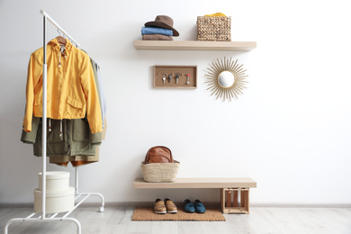 Photo of Hallway interior with stylish furniture, clothes and accessories
