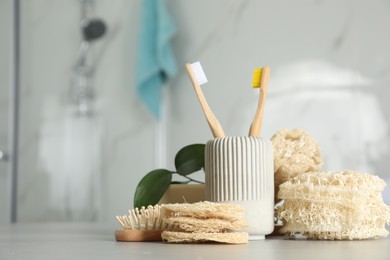 Photo of Composition with natural loofah sponges on table in bathroom. Space for text