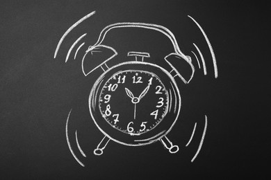 Photo of Drawn alarm clock on blackboard. School time