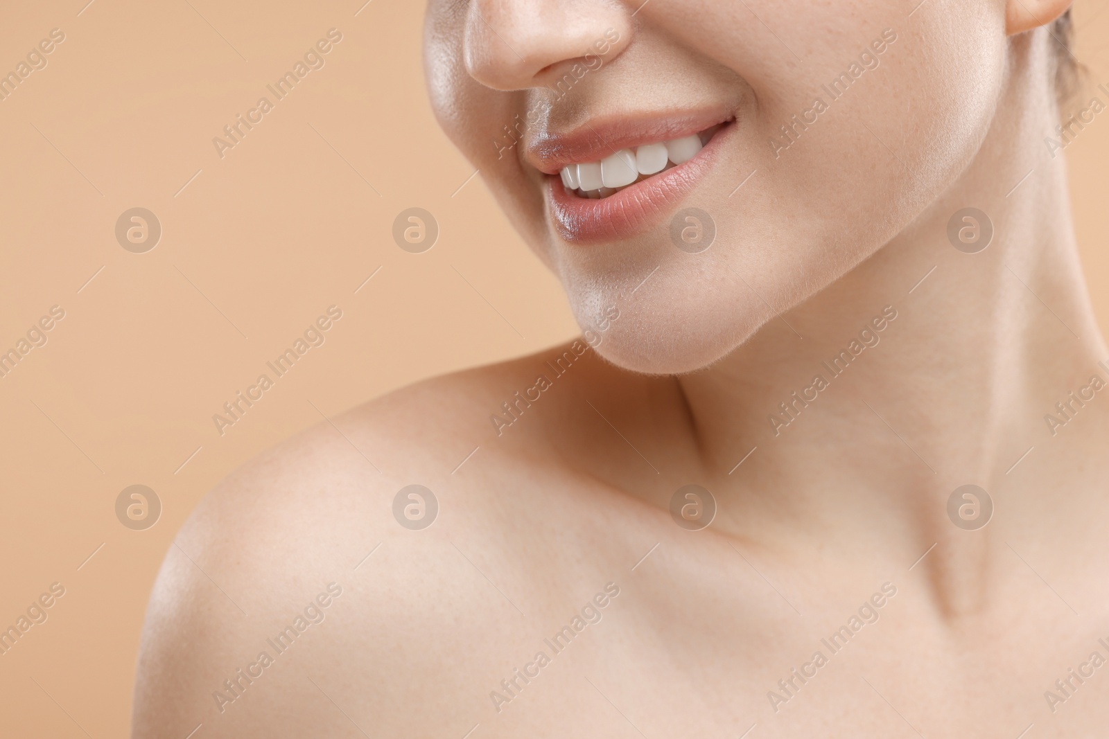 Photo of Beauty concept. Smiling woman on beige background, closeup