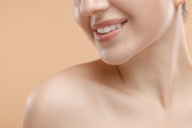 Photo of Beauty concept. Smiling woman on beige background, closeup