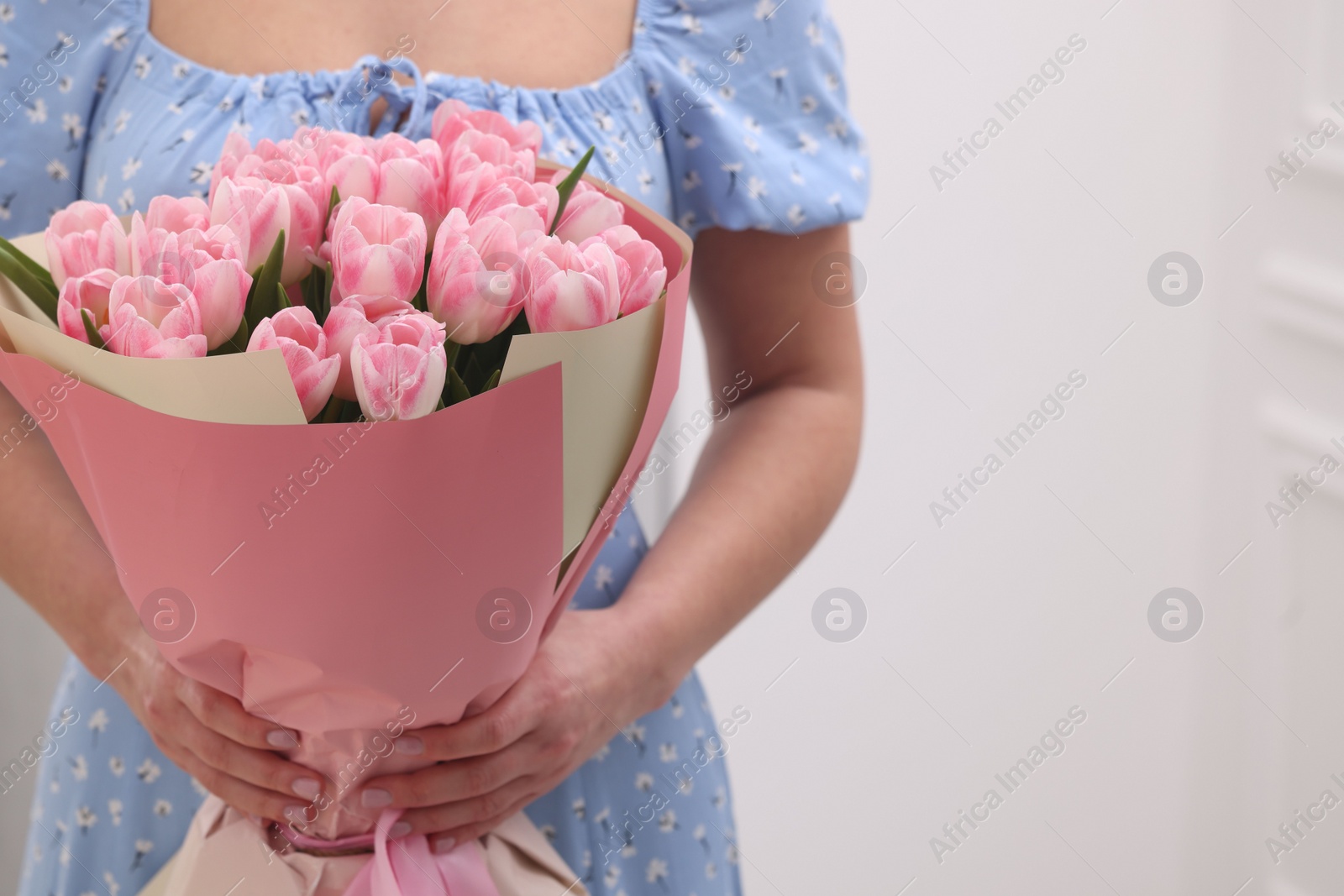 Photo of Woman with bouquet of beautiful fresh tulips on blurred background, closeup