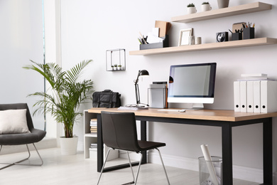 Photo of Modern computer on table in office interior. Stylish workplace