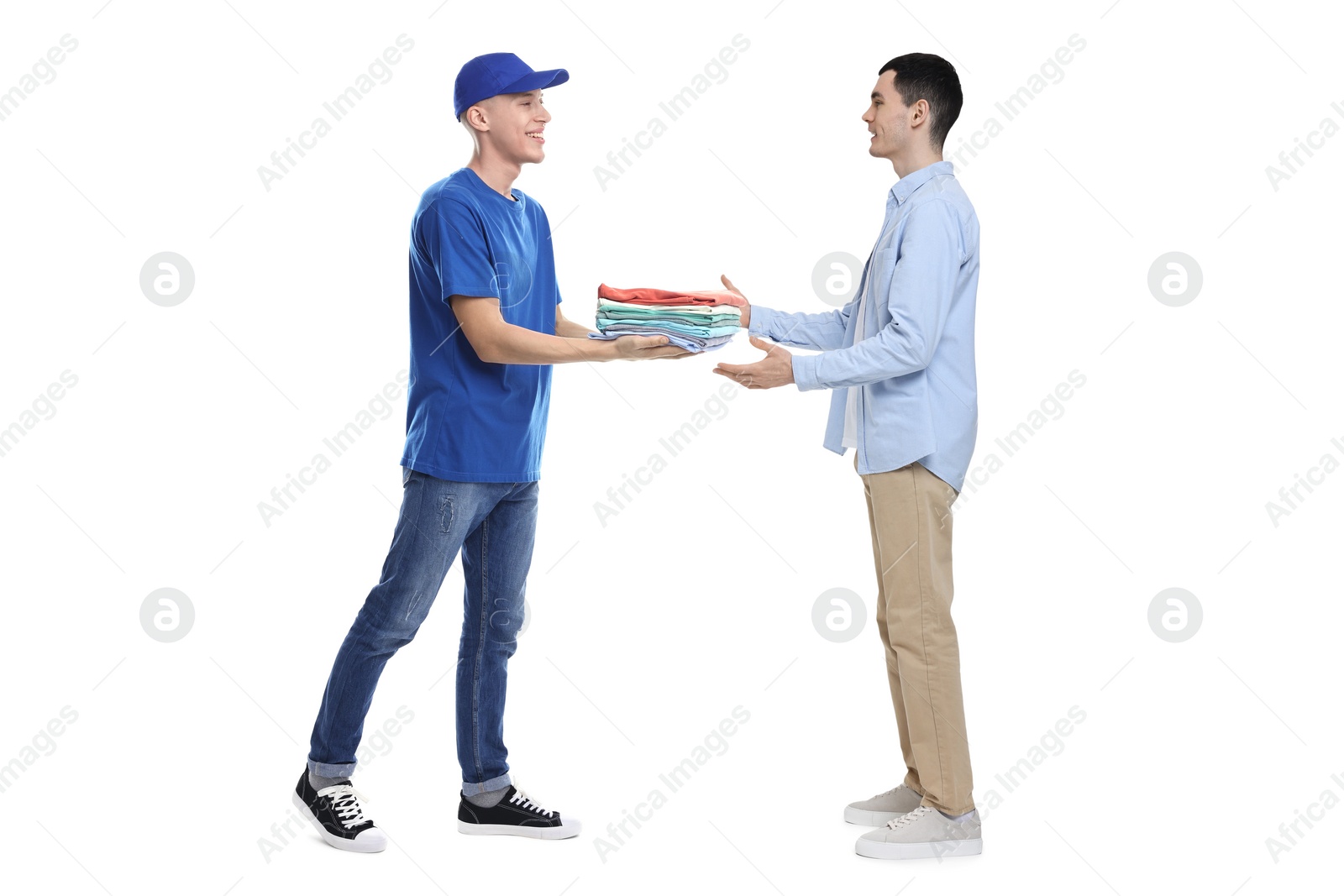 Image of Dry-cleaning delivery. Courier giving folded clothes to man on white background