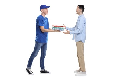 Dry-cleaning delivery. Courier giving folded clothes to man on white background