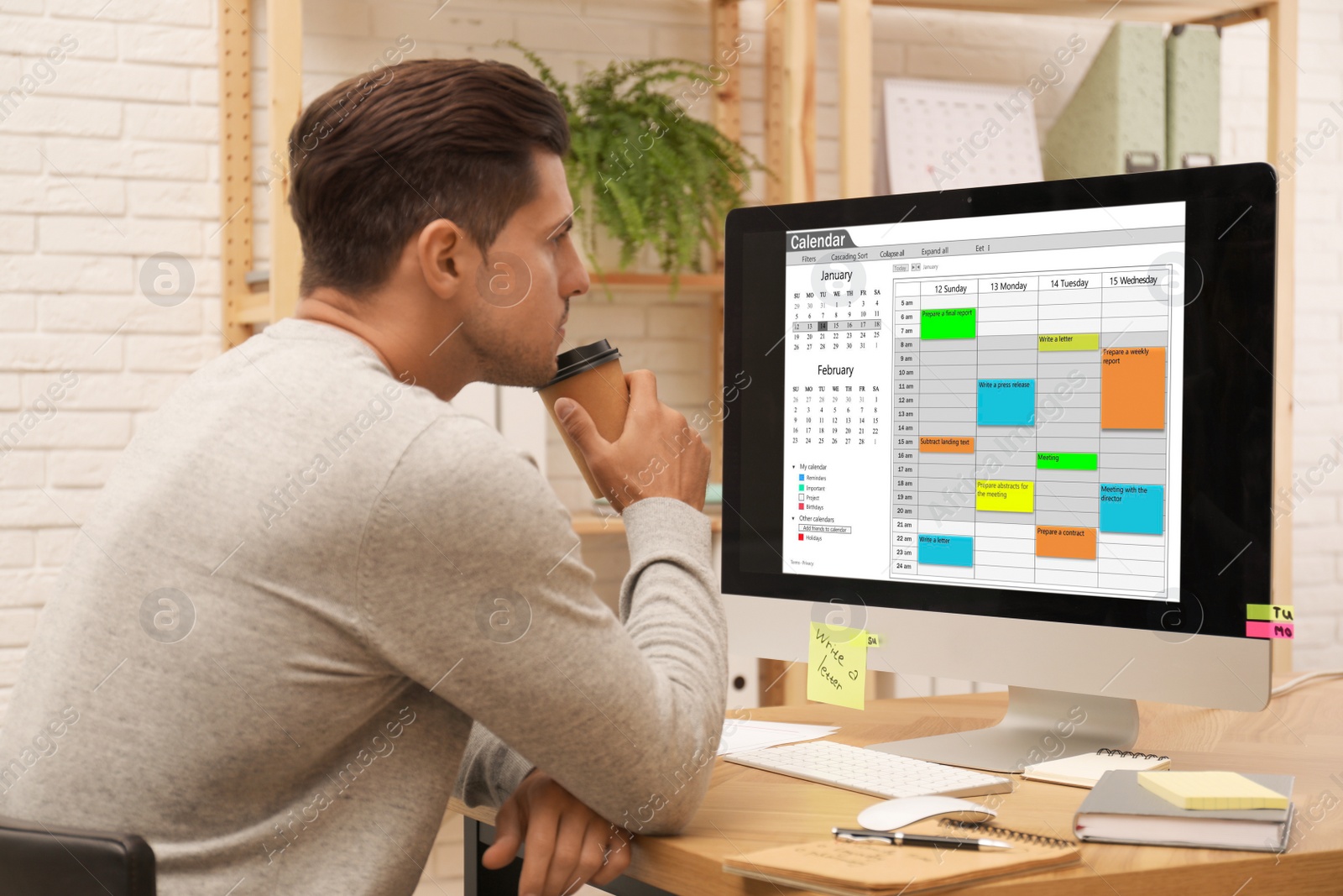 Photo of Handsome man using calendar app on computer in office