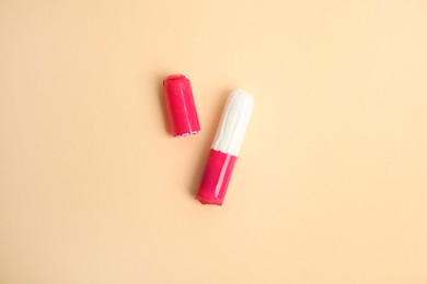 Photo of Tampon with package on beige background, flat lay
