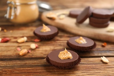 Photo of Delicious peanut butter cups on wooden table