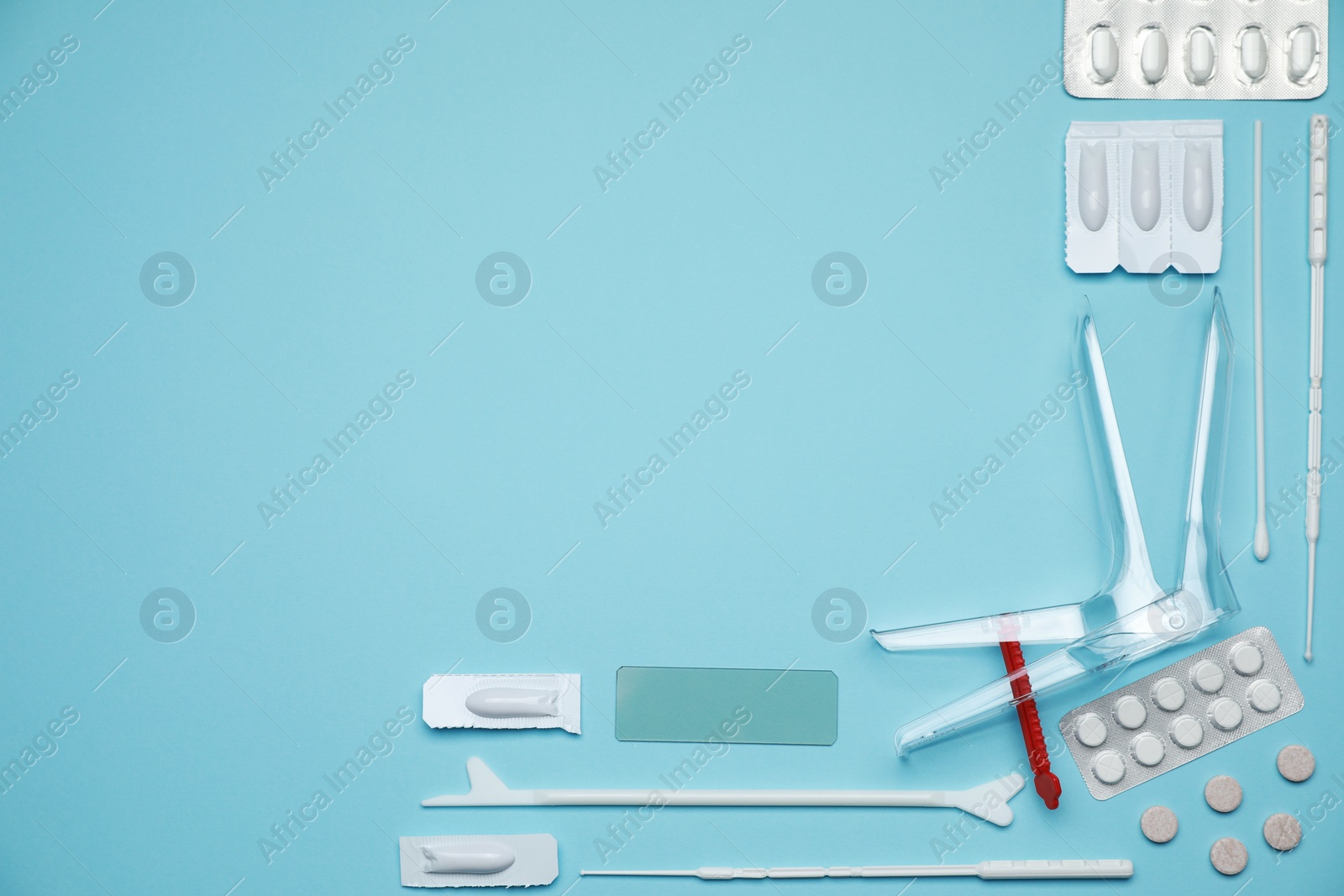 Photo of Sterile gynecological examination kit and pills on light blue background, flat lay. Space for text