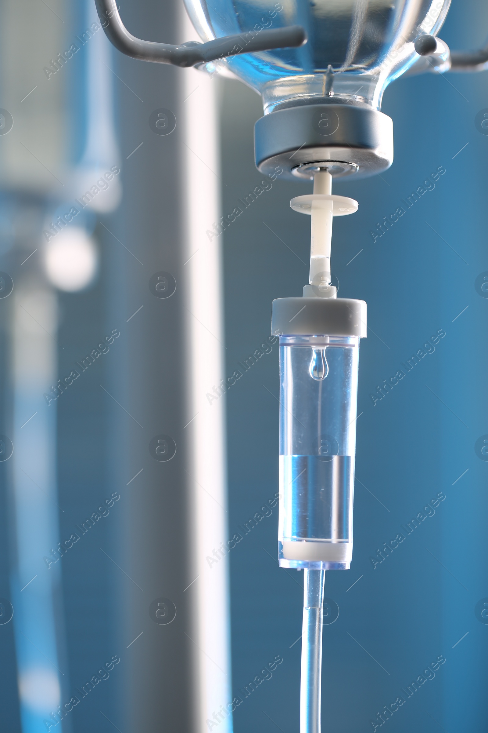 Photo of IV drip chamber against blurred light background