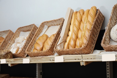 Trays with different breads on shelf in bakery