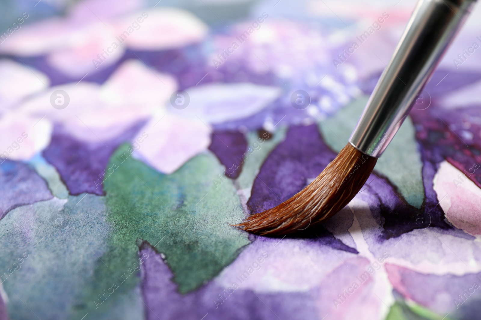 Photo of Painting flowers with watercolor on paper, closeup