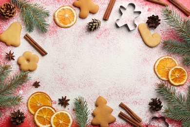 Frame of Christmas decor and flour on red background, flat lay. Space for text