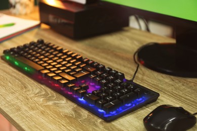 Photo of Modern RGB keyboard and mouse on wooden table indoors, closeup