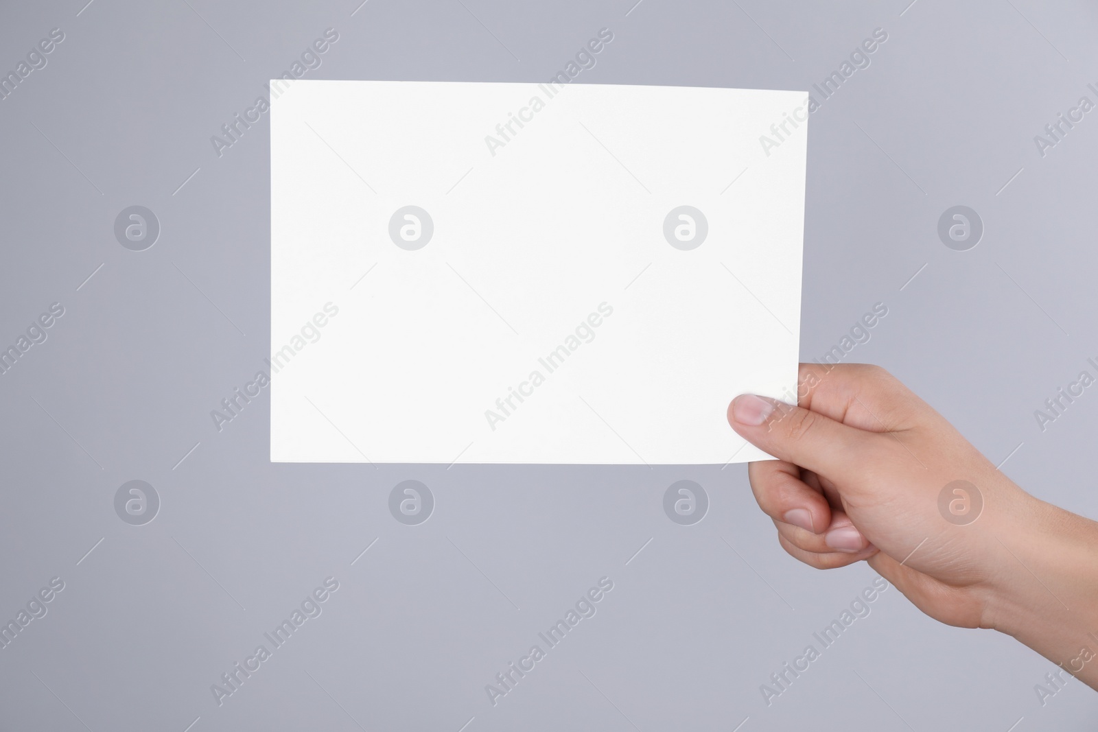 Photo of Man holding blank flyer on grey background, closeup. Mock up for design