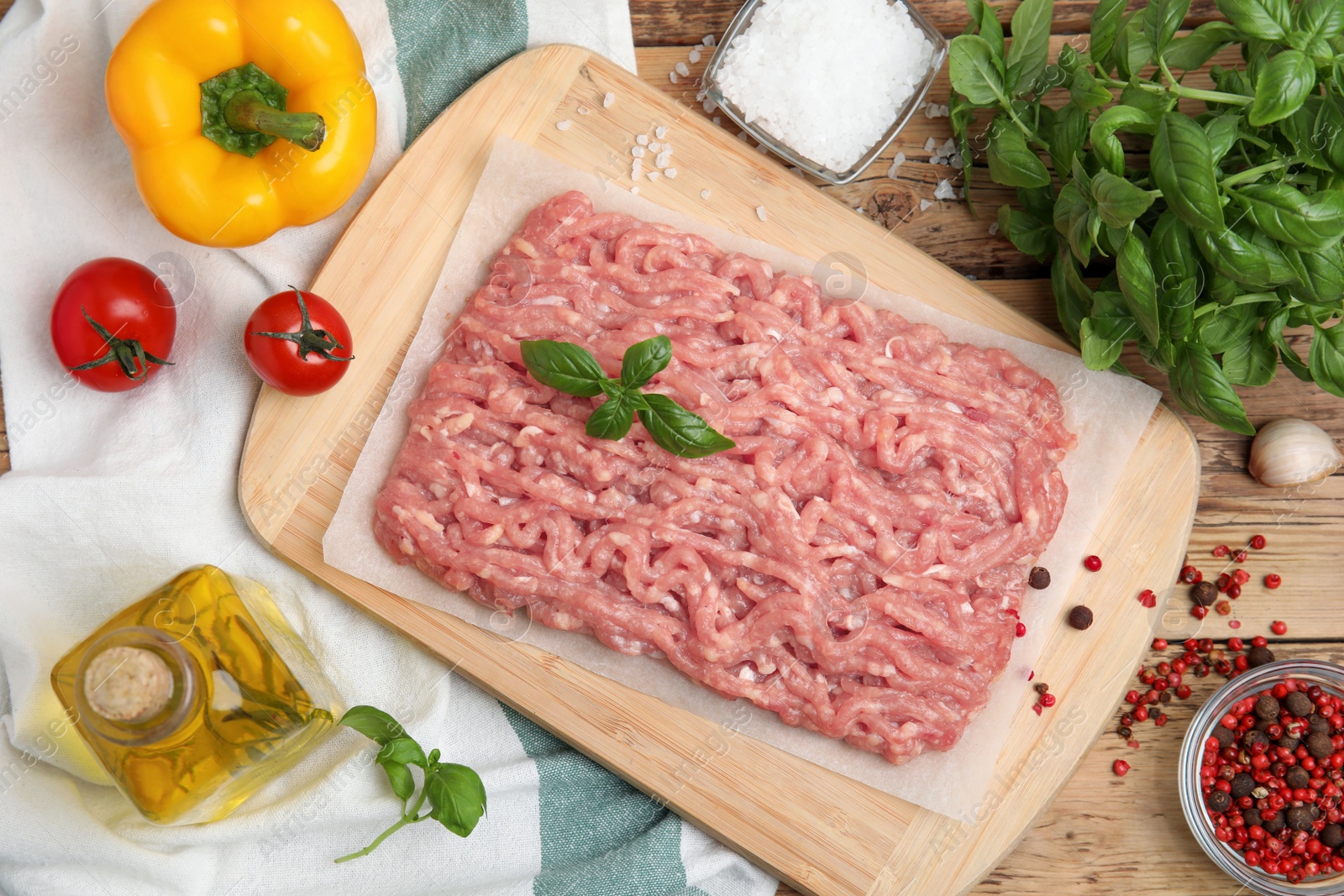 Photo of Raw chicken minced meat and ingredients on wooden table, flat lay