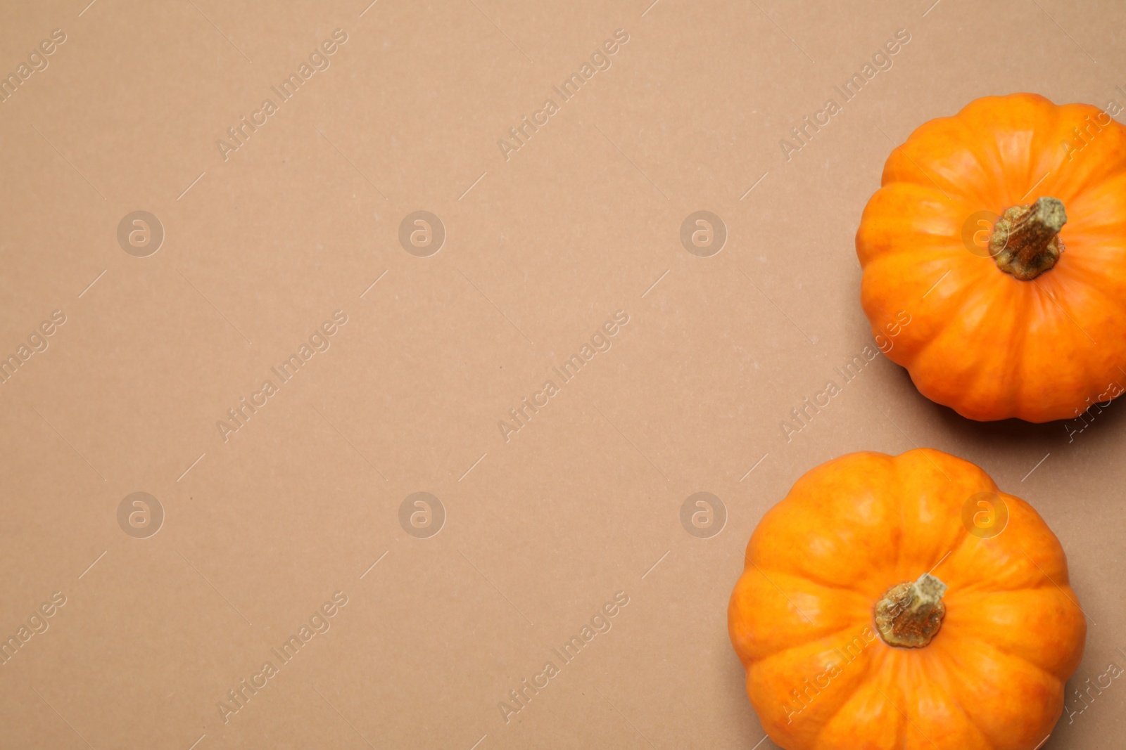 Photo of Fresh ripe pumpkins on brown background, flat lay. Space for text