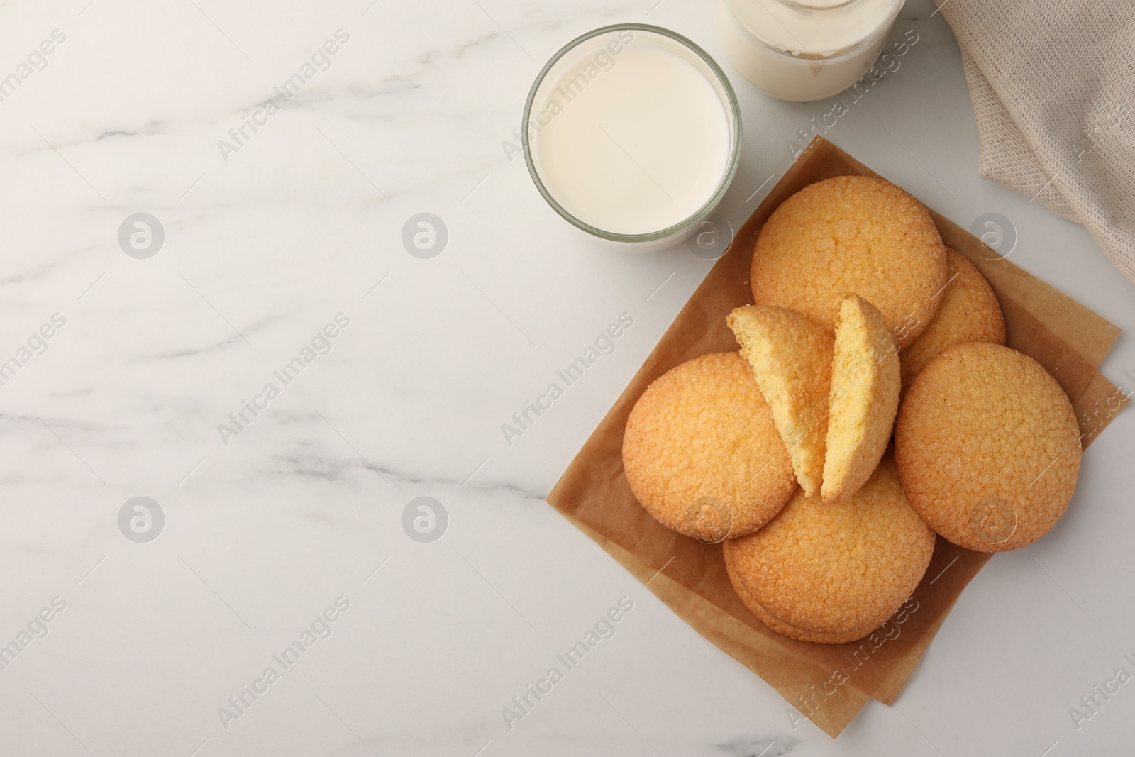 Photo of Delicious Danish butter cookies and milk on white marble table, flat lay. Space for text