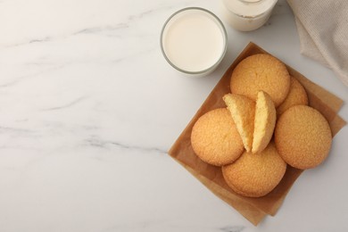 Photo of Delicious Danish butter cookies and milk on white marble table, flat lay. Space for text