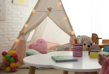 Photo of Cute play tent in child's room. Interior design