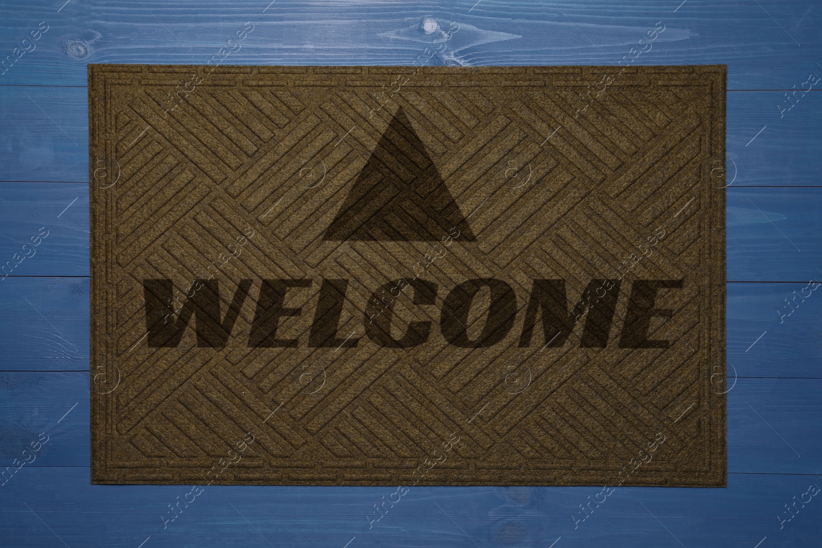 Image of Door mat with word Welcome on blue wooden floor, top view