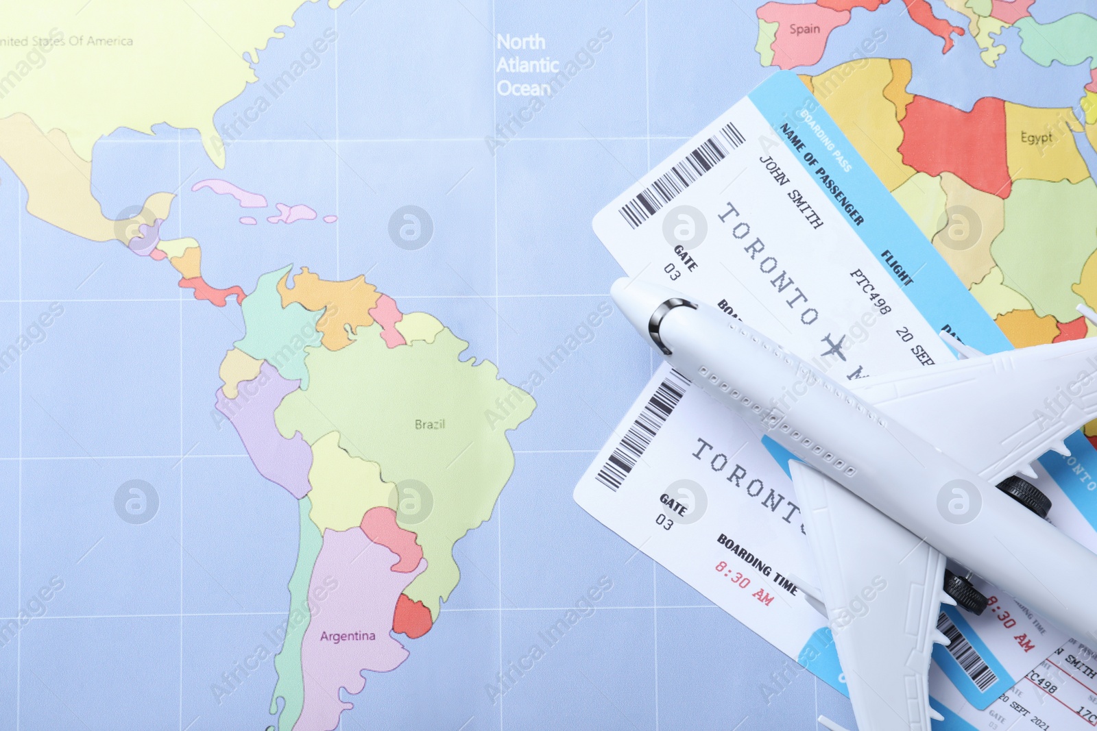 Photo of Toy airplane and tickets on world map, flat lay. Travel agency concept