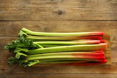 Fresh rhubarb stalks on wooden table, top view. Space for text