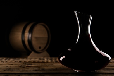 Elegant decanter with red wine on table against dark background