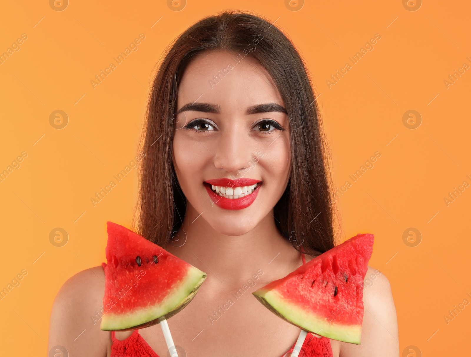 Photo of Beautiful young woman posing with watermelon on color background