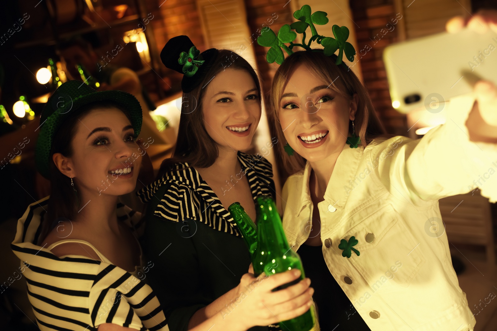 Photo of Women with beer taking selfie in pub. St Patrick's day celebration
