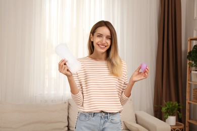 Young woman with menstrual cup and disposable pad at home