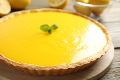 Photo of Delicious homemade lemon pie with mint on wooden table, closeup