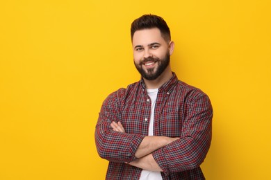 Photo of Portrait of happy young man with mustache on yellow background. Space for text