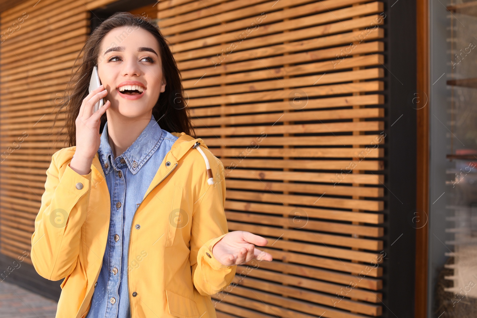 Photo of Beautiful young woman talking on phone outdoors