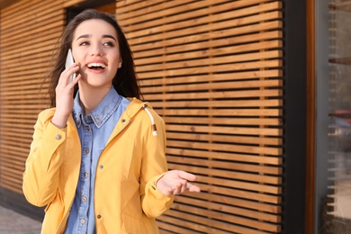 Photo of Beautiful young woman talking on phone outdoors