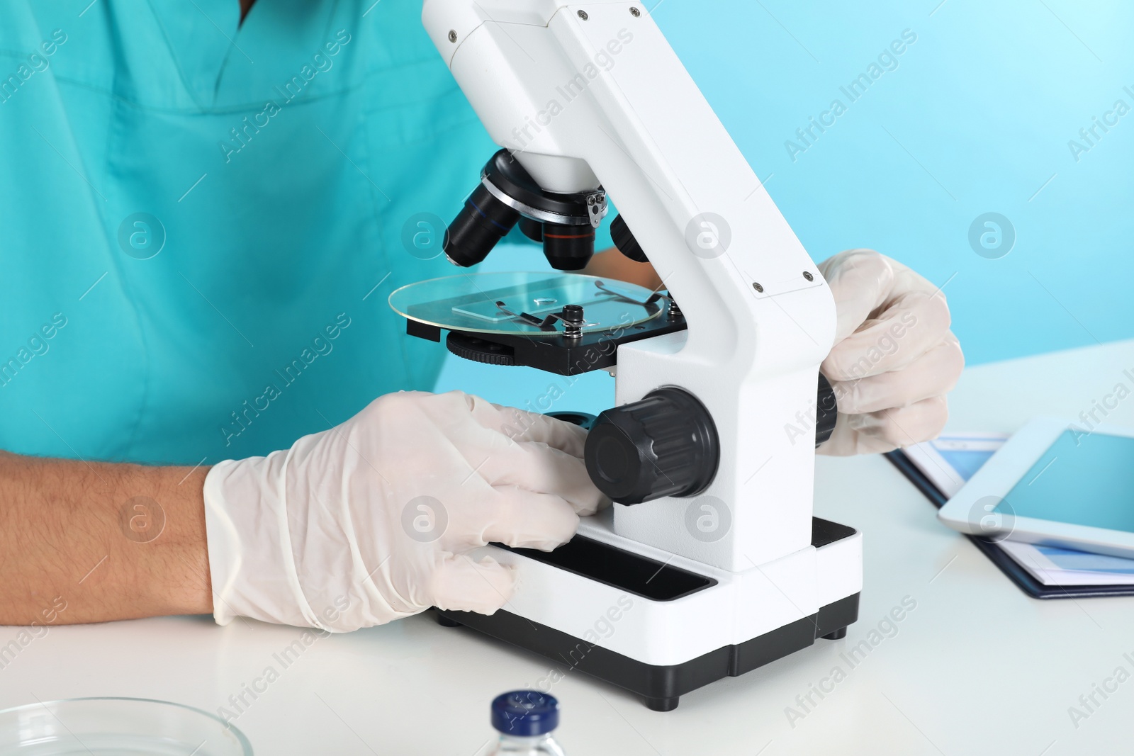 Photo of Male doctor using microscope at table, closeup. Medical object