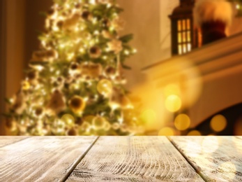 Image of Empty wooden surface and blurred view of Christmas tree in room, space for text. Interior design