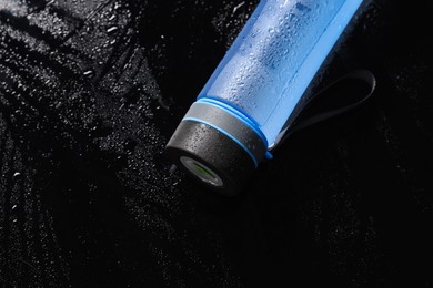 Photo of Wet thermo bottle on black table, top view