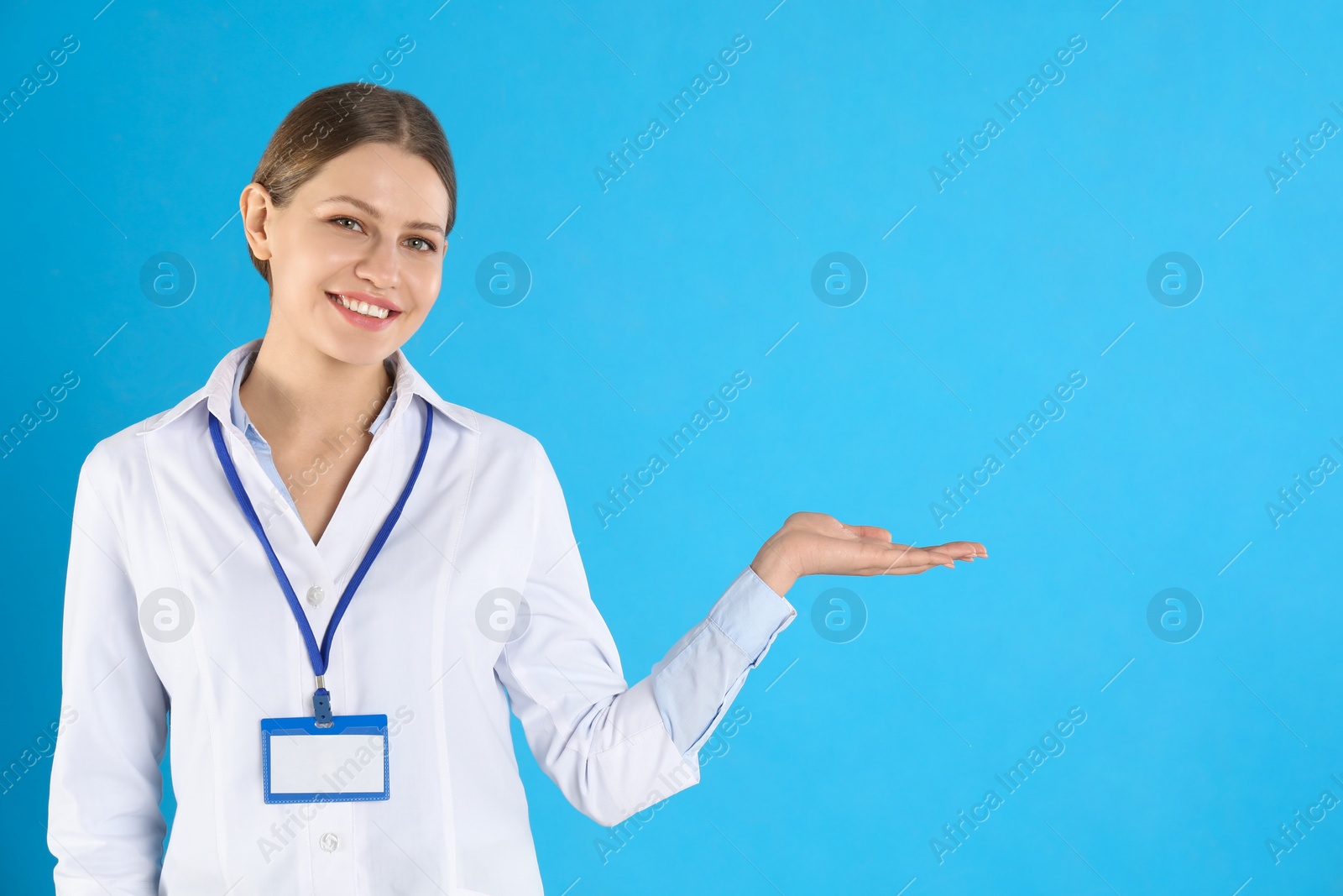 Photo of Portrait of young doctor on blue background, space for text