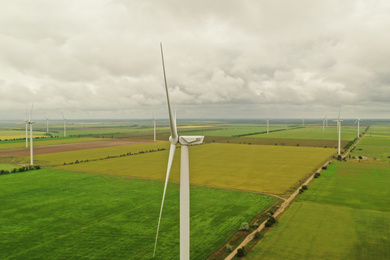 Aerial view of wind turbines in field on cloudy day
