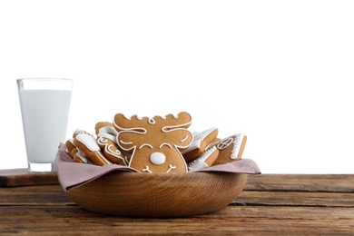 Tasty Christmas cookies and milk on wooden table against white background