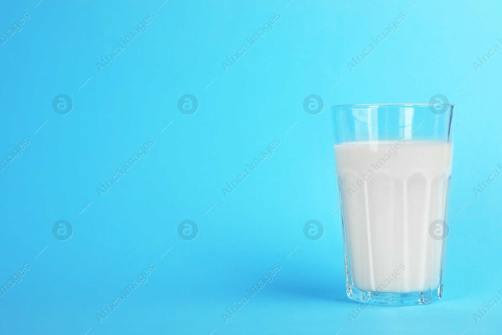 Photo of Glass with fresh milk on color background. Space for text