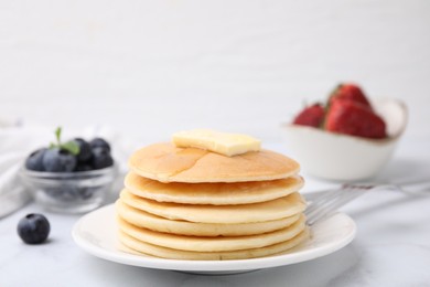 Photo of Delicious pancakes with butter and honey on white marble table, closeup