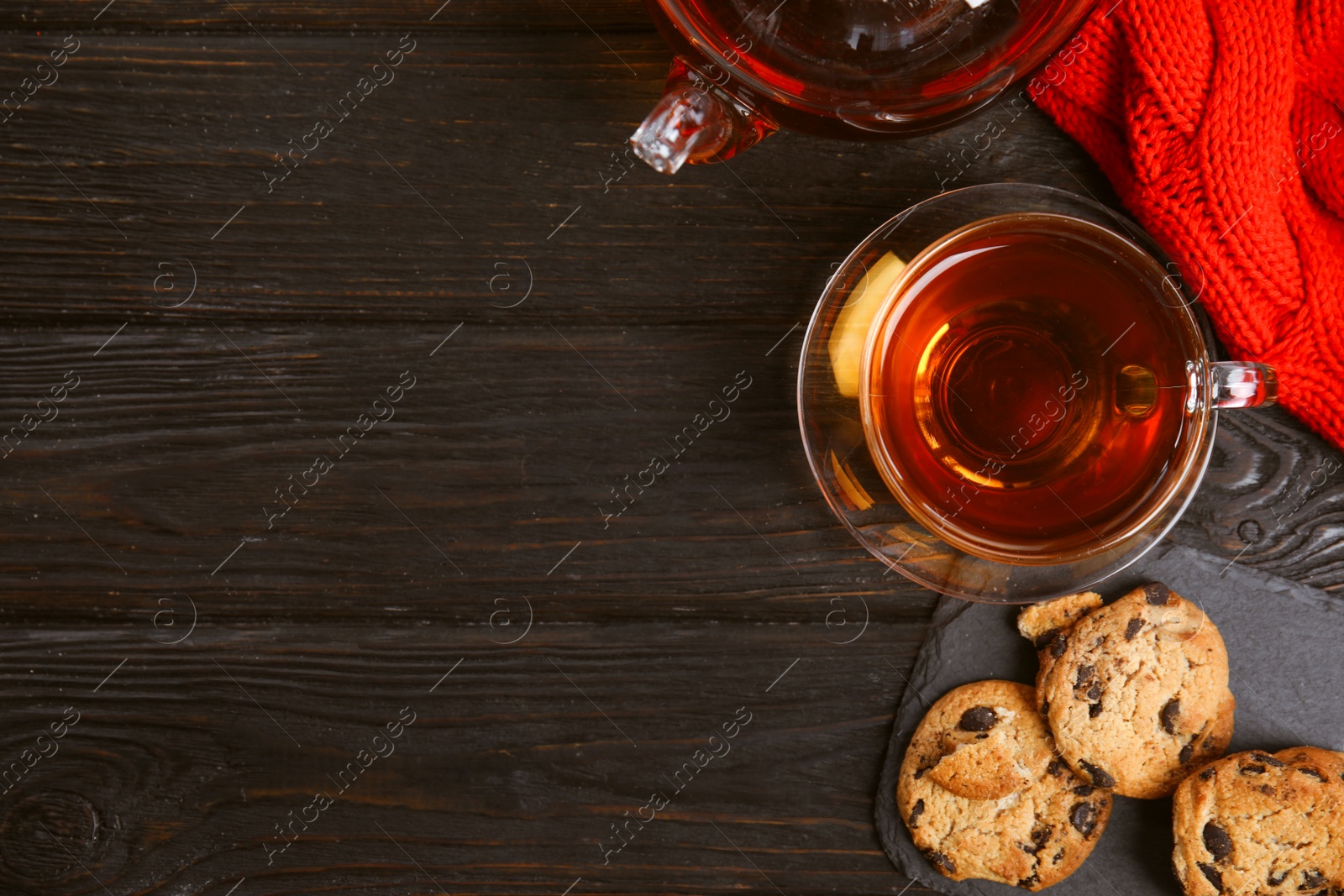 Photo of Flat lay composition with cup of hot tea on black wooden table, space for text. Winter drink